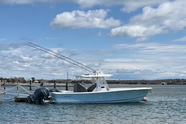 Slide: The Image of 2015 Regulator 34 boat docked on a calm, scenic waterway under a partly cloudy sky. - 13