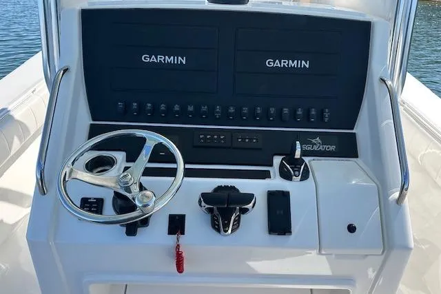 Slide: The Image of 2015 Regulator 34 boat dashboard with dual Garmin displays and steering wheel. - 14