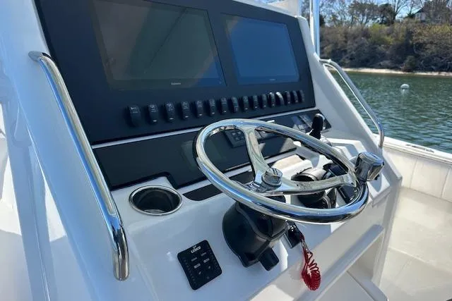 Slide: The Image of 2015 Regulator 34 boat helm with dual screens and stainless steel steering wheel. - 16