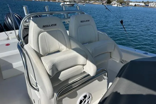Slide: The Image of 2015 Regulator 34 boat with dual white cushioned seats on a sunny day. - 21