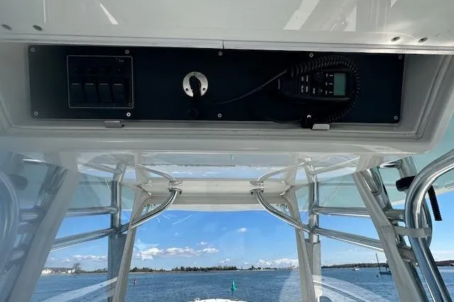 Slide: The Image of 2015 Regulator 34 boat console with radio and switches, overlooking calm waters. - 23