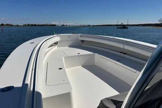 Slide: The Image of 2015 Regulator 34 boat on calm water, showcasing spacious deck and sleek design. - 25