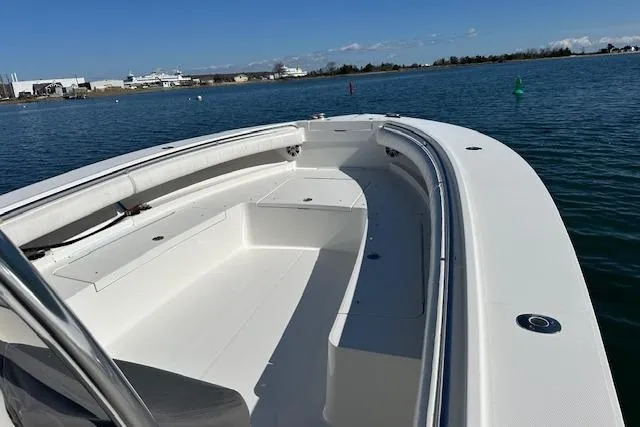 Slide: The Image of 2015 Regulator 34 boat on calm water, showcasing spacious deck and sleek design. - 26