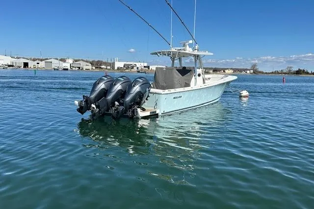 Slide: The Image of 2015 Regulator 34 boat with triple outboard engines on calm water. - 3