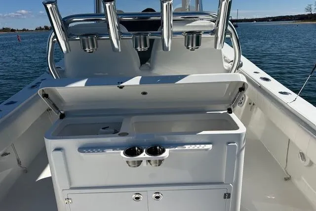 Slide: The Image of 2015 Regulator 34 boat with open storage compartment and rod holders on deck. - 30
