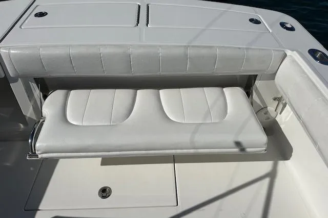 Slide: The Image of 2015 Regulator 34 boat with white cushioned seating and storage compartment. - 31