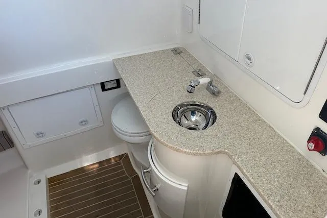 Slide: The Image of 2015 Regulator 34 boat interior with sink, countertop, and toilet in compact bathroom. - 44