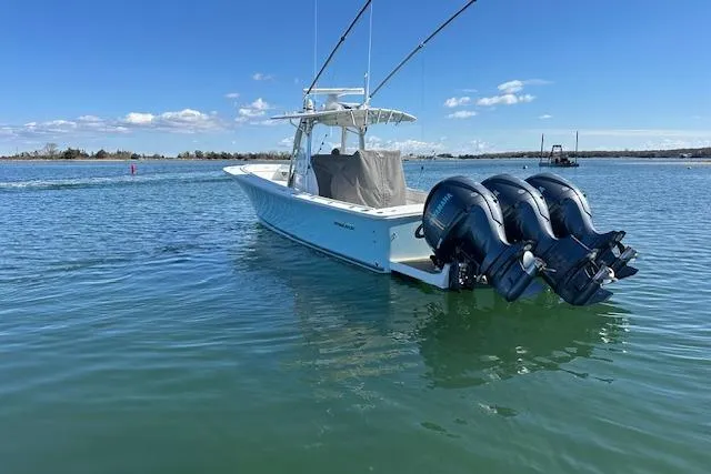 Slide: The Image of 2015 Regulator 34 boat with triple outboard engines on calm water. - 5