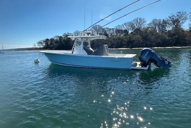 Slide: The Image of 2015 Regulator 34 boat on calm water, clear sky, wooded shoreline in background. - 8