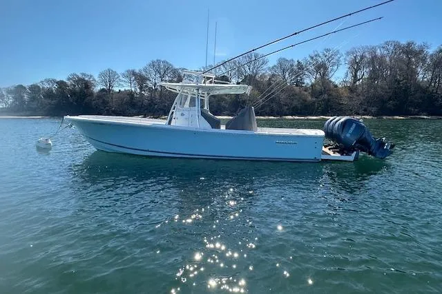 Slide: The Image of 2015 Regulator 34 boat on calm water, surrounded by trees. - 9