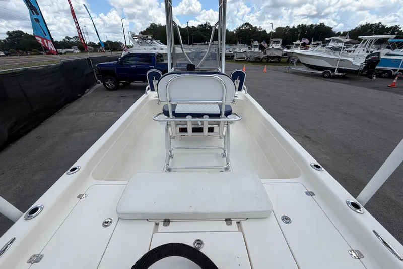 Slide: The Image of 2006 ShearWater 2200Z boat interior with seating, parked in a marina. - 13