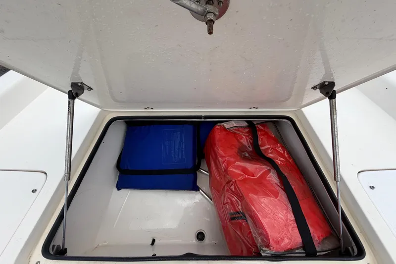 Slide: The Image of Open storage compartment on 2006 ShearWater 2200Z boat with red and blue gear. - 38