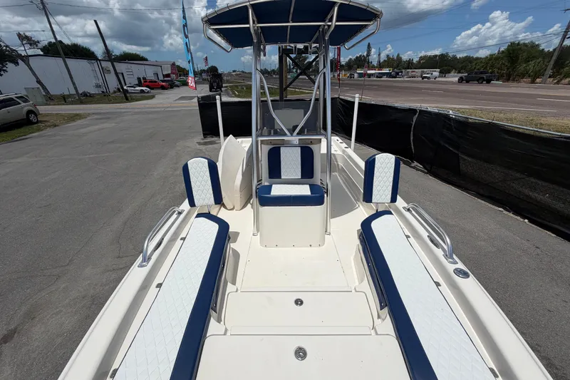 Slide: The Image of 2006 ShearWater 2200Z boat interior with blue and white seating, parked outdoors. - 42