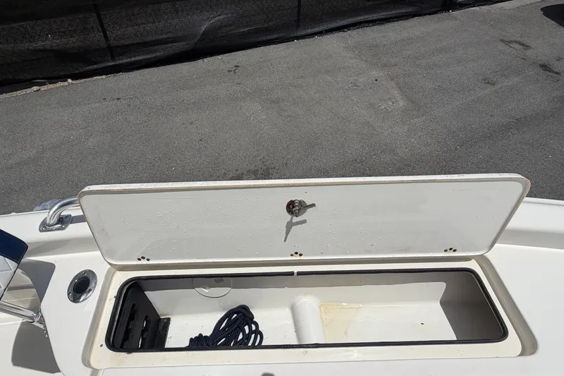 Slide: The Image of Open storage compartment on a 2006 ShearWater 2200Z boat, featuring a coiled rope inside. - 44
