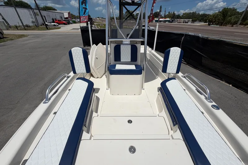 Slide: The Image of 2006 ShearWater 2200Z boat interior with blue and white seating, parked outdoors. - 47