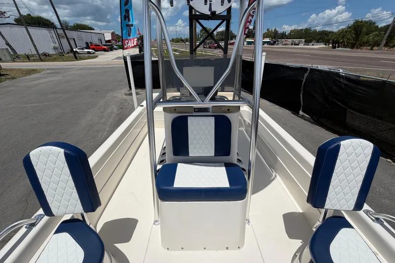 Slide: The Image of 2006 ShearWater 2200Z boat interior with blue and white seating, parked outdoors. - 48