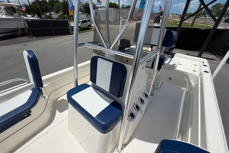 Slide: The Image of 2006 ShearWater 2200Z boat interior with blue and white seating, docked outdoors. - 51