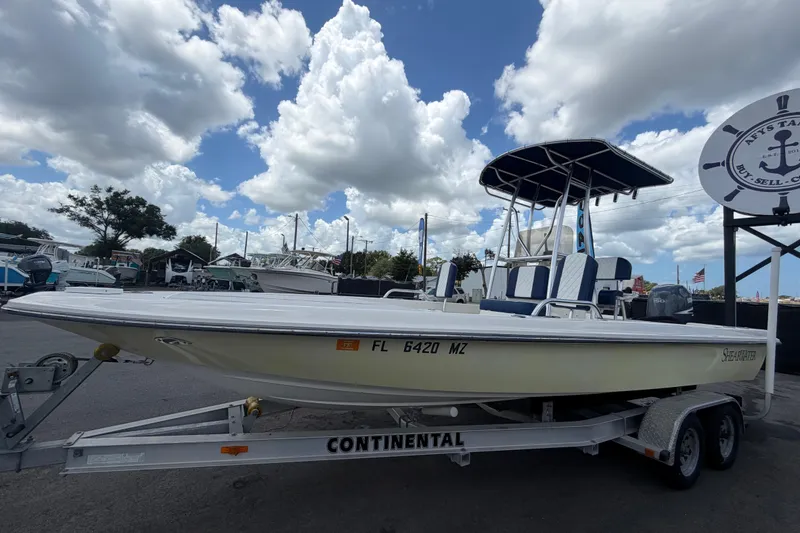 Slide: The Image of 2006 ShearWater 2200Z boat on trailer under cloudy sky at marina. - 9