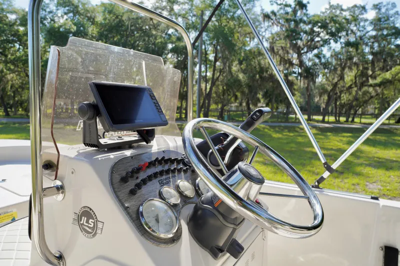 Slide: The Image of 2023 Carolina Skiff 178 JLS boat dashboard with steering wheel and navigation system. - 11