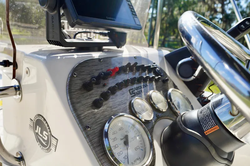 Slide: The Image of 2023 Carolina Skiff 178 JLS boat dashboard with steering wheel and control panel. - 14