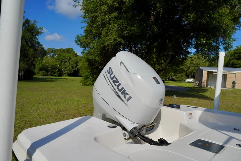 Slide: The Image of 2023 Carolina Skiff 178 JLS with Suzuki outboard motor in a grassy area. - 17