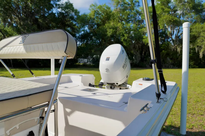 Slide: The Image of 2023 Carolina Skiff 178 JLS boat with Suzuki outboard motor in a grassy area. - 18