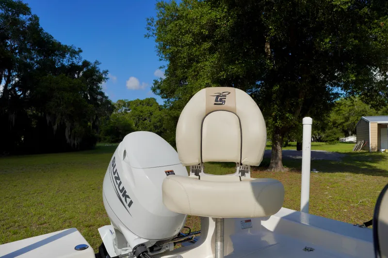 Slide: The Image of 2023 Carolina Skiff 178 JLS boat seat and Suzuki engine in a grassy area. - 21