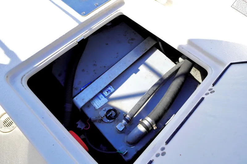 Slide: The Image of 2023 Carolina Skiff 178 JLS boat compartment with visible fuel tank and hoses. - 22