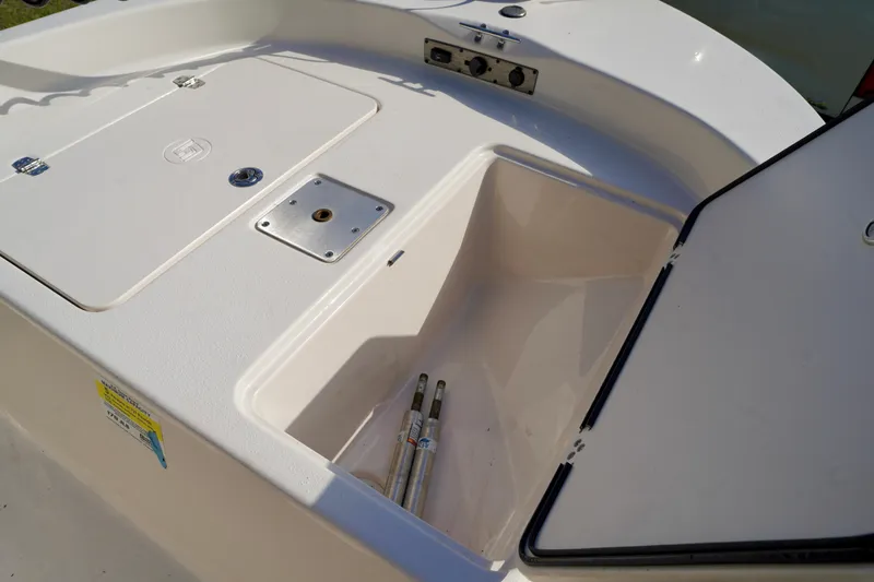 Slide: The Image of 2023 Carolina Skiff 178 JLS boat storage compartment with open hatch and visible equipment. - 6