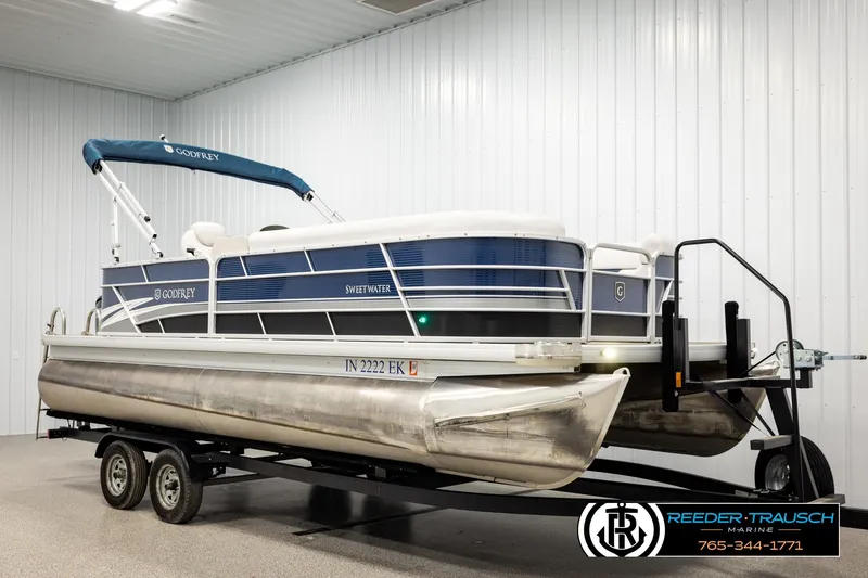 Slide: The Image of 2022 Godfrey Sweetwater 2286 pontoon boat on trailer in indoor showroom. - 2