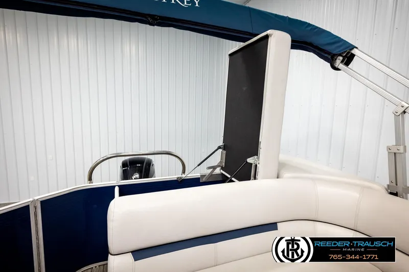 Slide: The Image of 2022 Godfrey Sweetwater 2286 pontoon boat interior with white seating and blue canopy. - 25