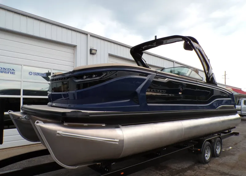 The Image of 2026 Godfrey SanPan ULW pontoon boat on trailer outside building. - 1