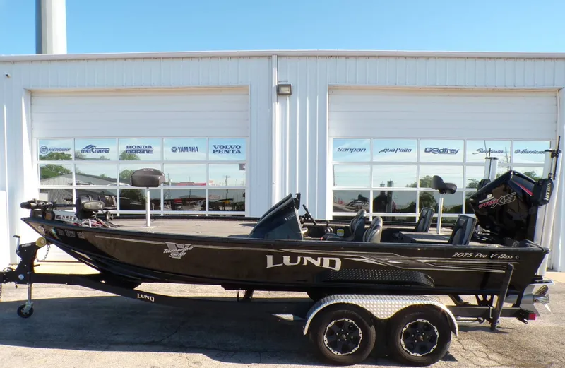 The Image of 2019 Lund 2075 Pro V Bass XS boat in front of a store. - 1