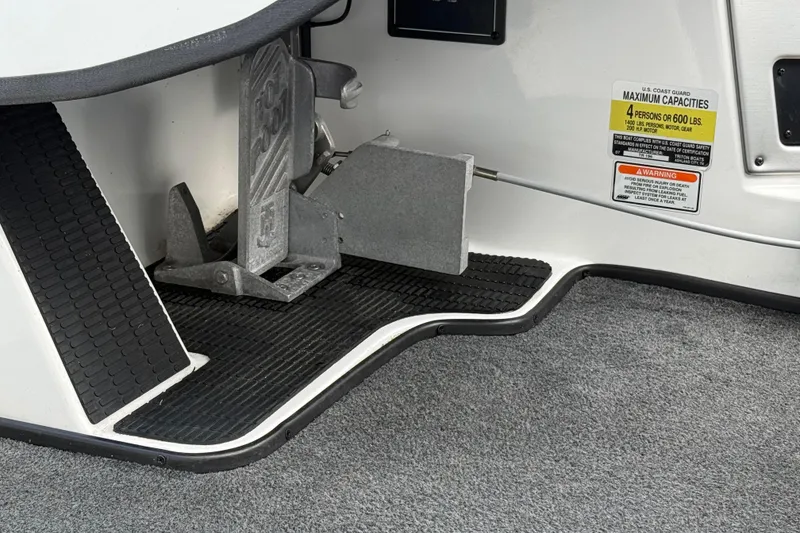 Slide: The Image of 2007 Triton TR-196 boat interior showing foot pedal and capacity warning label. - 16