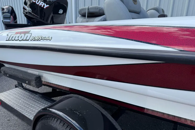 Slide: The Image of 2007 Triton TR-196 boat with red and white detailing, parked on a trailer. - 2