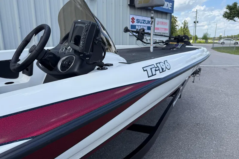 Slide: The Image of 2007 Triton TR-196 boat with steering console, parked outdoors near dealership signs. - 3