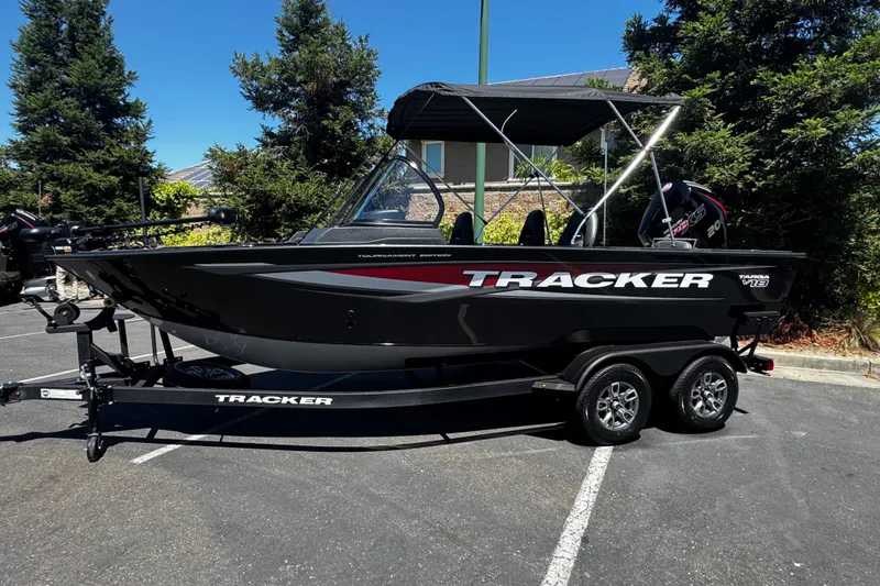 The Image of 2026 Tracker Targa V-18 Combo boat on trailer, parked outdoors, with canopy and sleek design. - 0