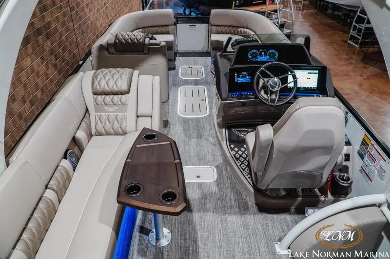 Slide: The Image of 2026 Bennington 27QXSBAT2 pontoon boat interior with luxurious seating and modern dashboard. - 11