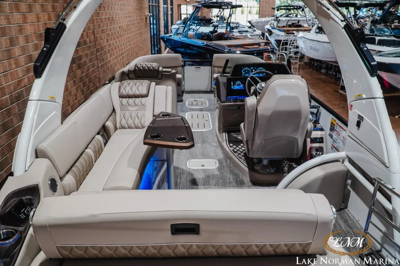 Slide: The Image of Luxurious 2026 Bennington 27QXSBAT2 pontoon boat interior with plush seating and modern dashboard. - 8