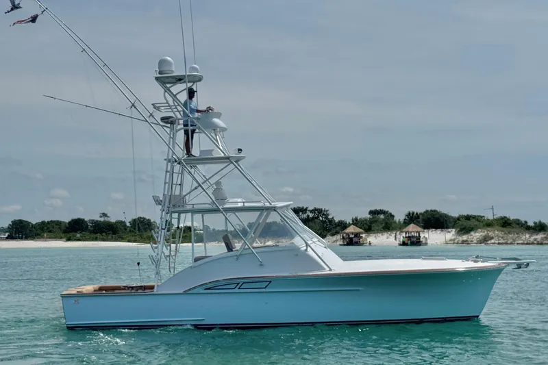 The Image of 2006 Miller Marine 36 yacht cruising on clear blue waters near a sandy shoreline. - 0