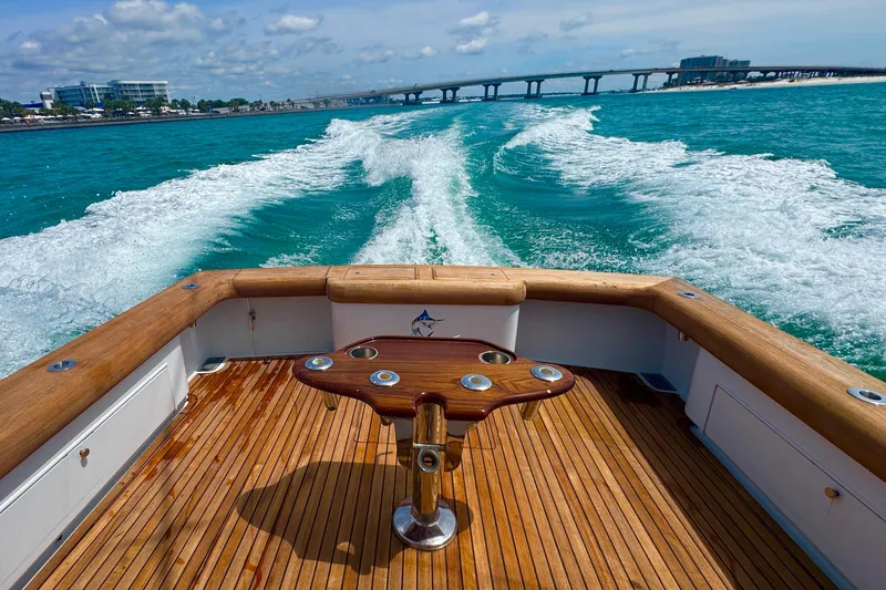 Slide: The Image of Miller Marine 36 boat cruising on turquoise waters, showcasing wooden deck and wake trail. - 13