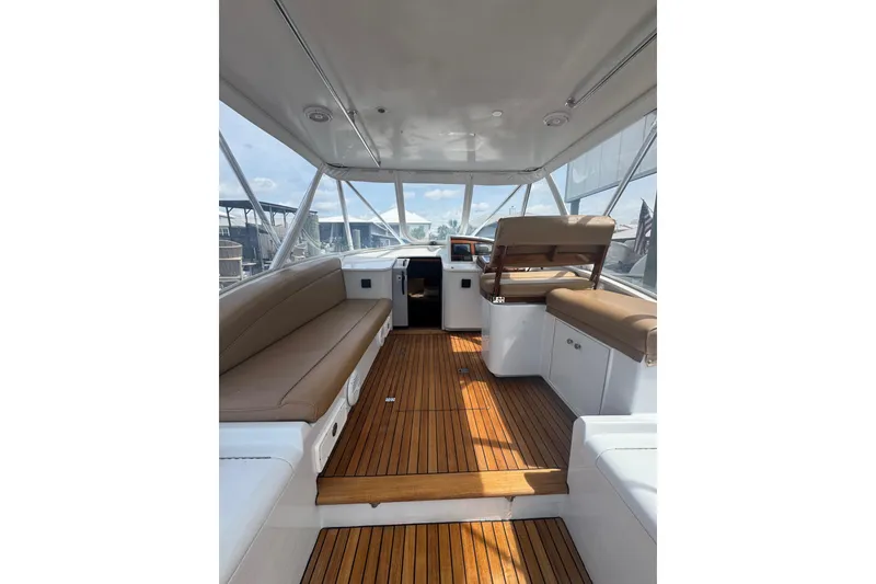 Slide: The Image of Interior of 2006 Miller Marine 36 boat with wooden flooring and cushioned seating. - 14