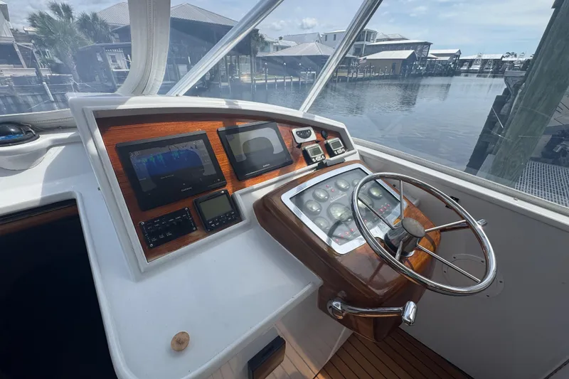 Slide: The Image of Helm of 2006 Miller Marine 36 boat with modern navigation instruments and wooden accents. - 15
