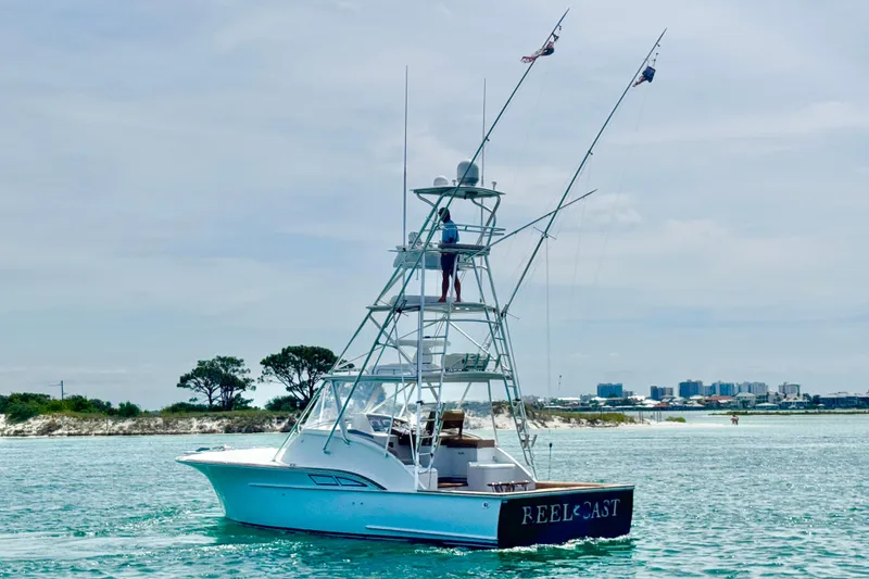 Slide: The Image of 2006 Miller Marine 36 boat cruising on clear waters near a sandy shoreline. - 5