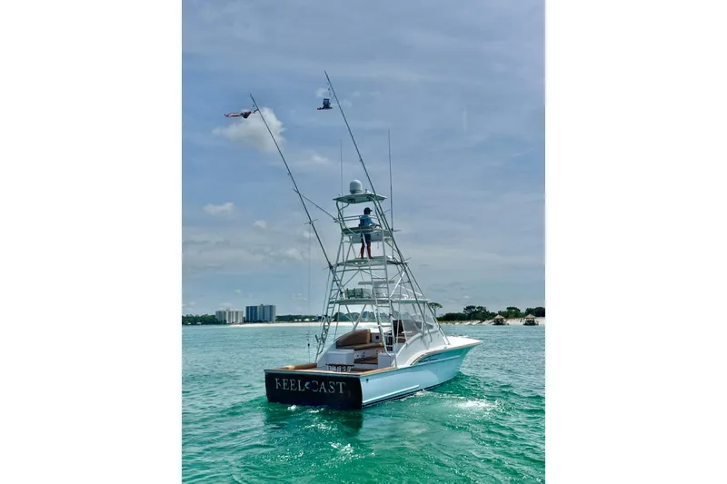 Slide: The Image of 2006 Miller Marine 36 boat on clear water with fishing rods and tower. - 6