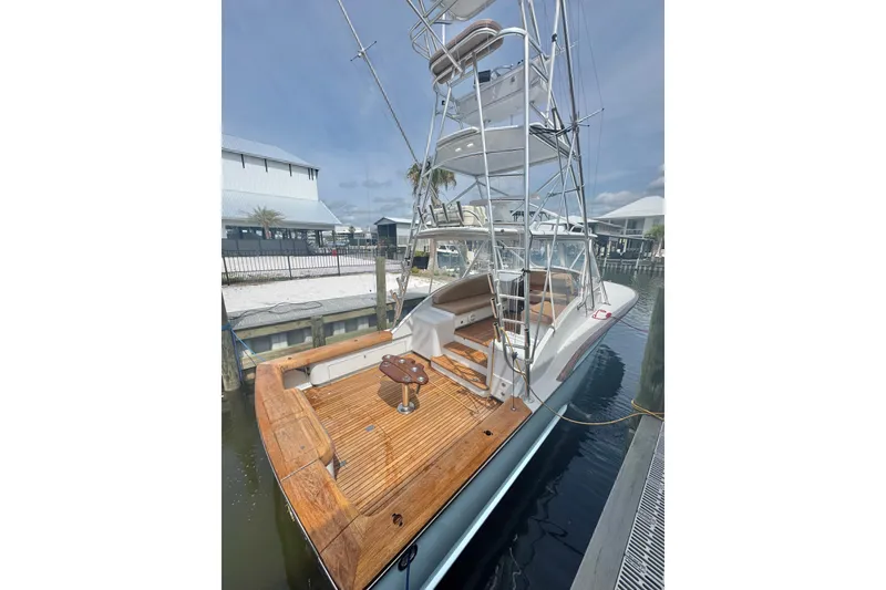 Slide: The Image of 2006 Miller Marine 36 yacht with wooden deck, docked at marina under clear sky. - 9