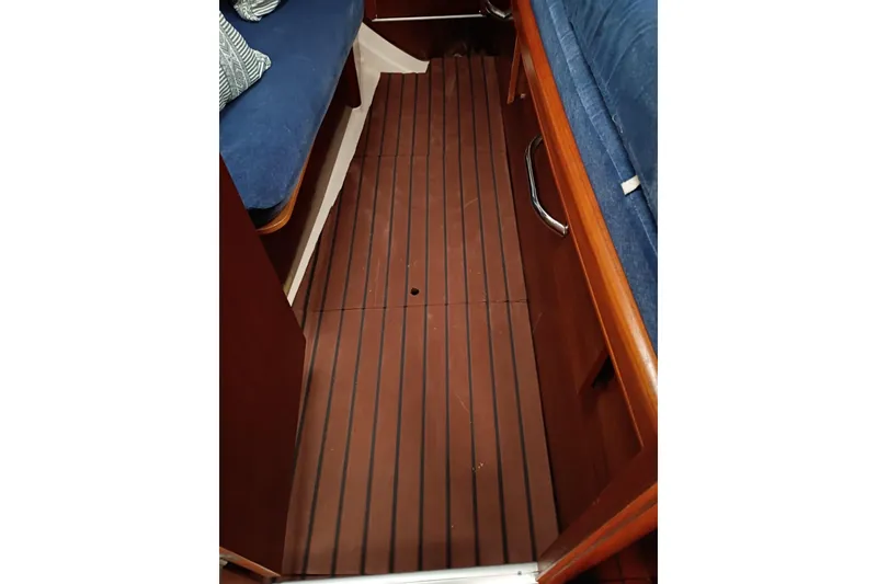 Slide: The Image of Interior view of 1998 Beneteau 411 sailboat with wooden flooring and blue seating. - 10