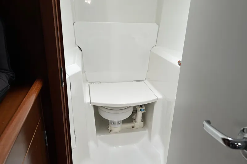 Slide: The Image of Beneteau 411 1998 yacht bathroom with compact marine toilet and white interior. - 11
