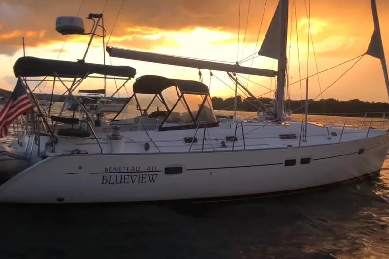 Slide: The Image of 1998 Beneteau 411 sailboat "Blueview" at sunset on the water. - 2