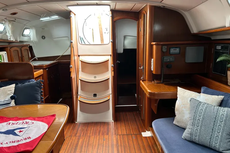 Slide: The Image of Interior of a 1998 Beneteau 411 sailboat with wooden furnishings and cozy seating. - 3